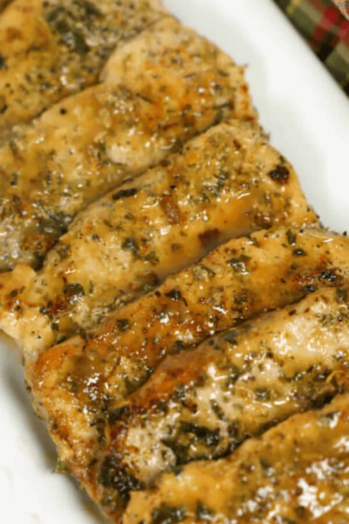 Slices of seasoned, cooked meat arranged in a row on a white plate, reminiscent of the savory elegance.