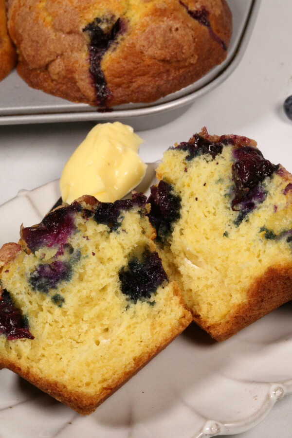 blueberry streusel muffins on white plate with honey butter,