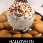 A Halloween Funfetti cake dip crowned with candy eyes and sprinkles, encircled by vanilla wafers.