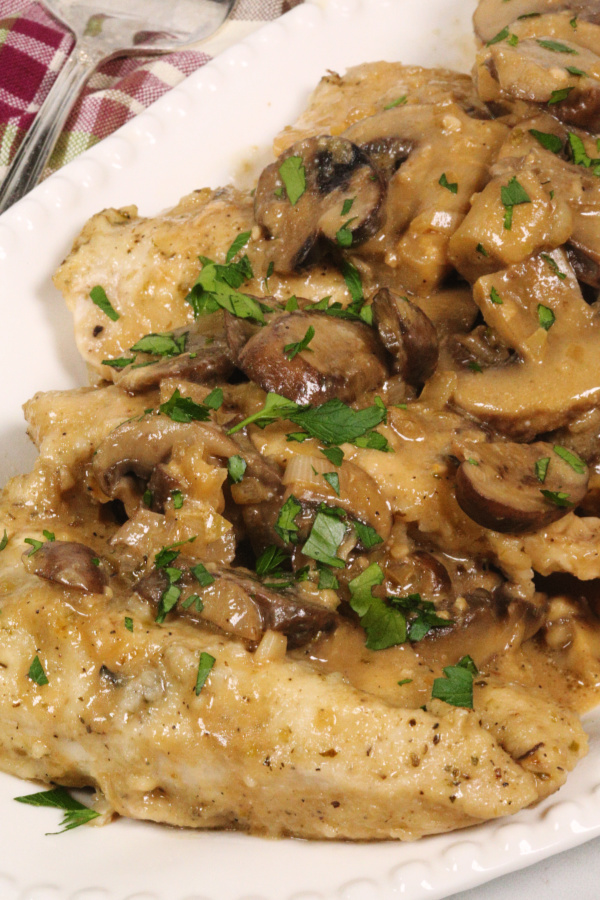 Instant Pot Chicken Marsala on a white platter with a plaid napkin