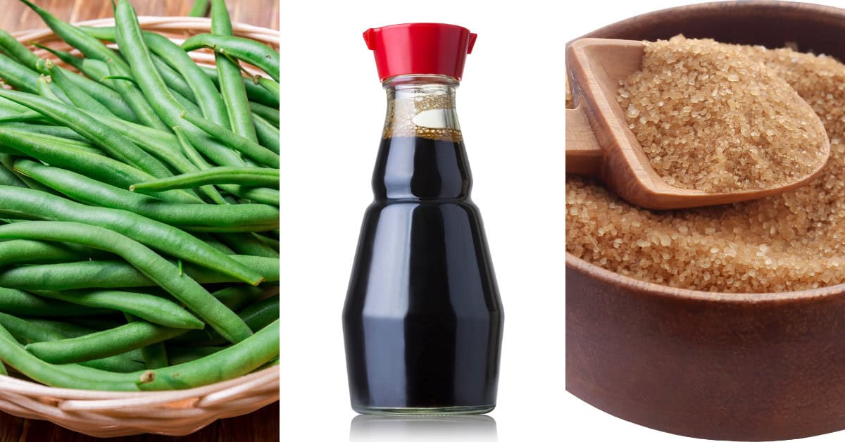 A basket of green beans, a bottle of soy sauce, and a bowl of brown sugar with a wooden scoop sit side by side, promising the perfect mix for spicy green beans.