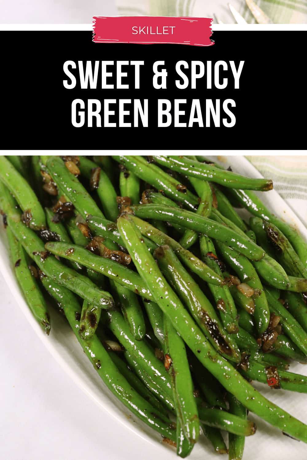 A plate of spicy green beans boasts a sweet and fiery kick, seasoned with visible spices and a delicate glaze.