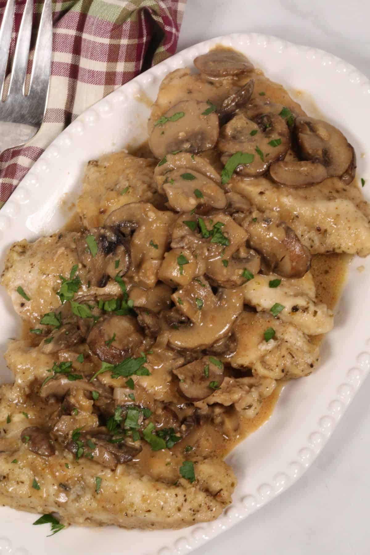 A serving platter with instant pot chicken marsala.