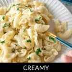 A plate of creamy Instant Pot Mac N Cheese, garnished with parsley, with a fork resting on the side. Text at the bottom reads "Creamy Instant Pot Mac N Cheese.
