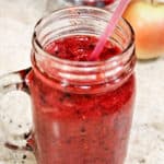 Berry smoothie in a mason jar with pink straw