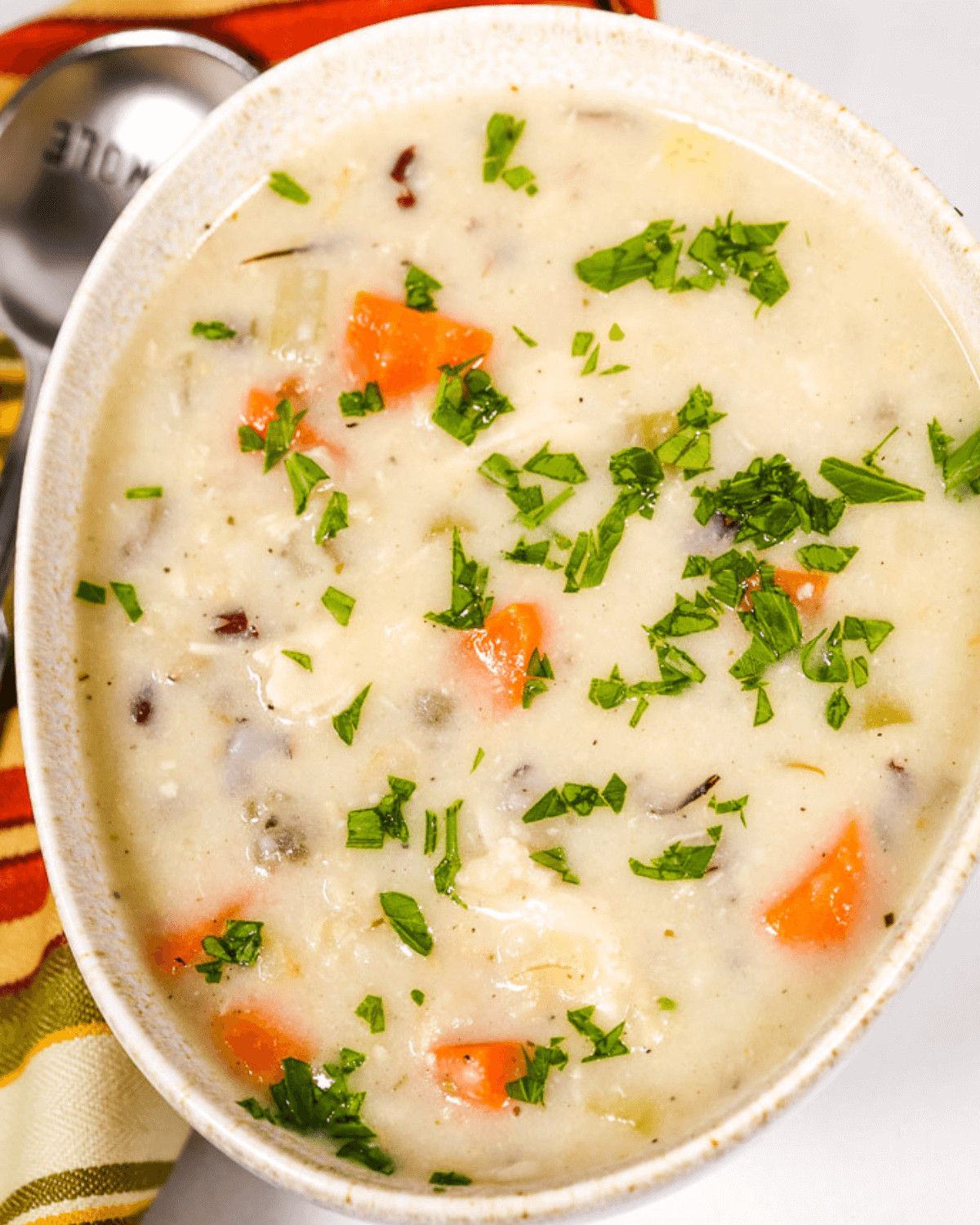 A creamy chicken soup with carrots and parsley.