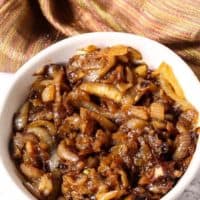 Caramelized onions in a white dish with tan napkin