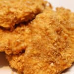 A white plate with cornflake chicken on it.