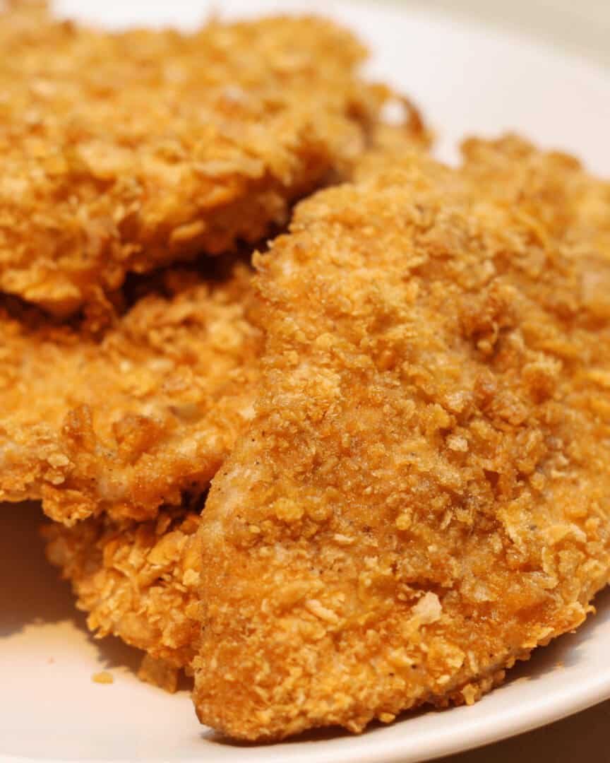 A white plate with cornflake chicken on it.