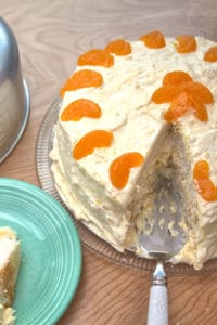 White cake with oranges with slice cut out