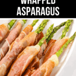 A pristine white plate features prosciutto wrapped asparagus spears, elegantly arranged diagonally. A "Wrapped Asparagus" label sits proudly at the top.