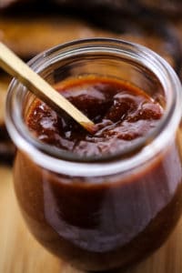homemade barbecue sauce in a jar with a gold spoon