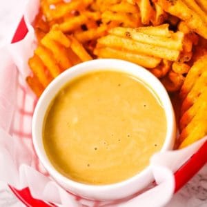 Closeup on Copycat Chick Fila A sauce with waffle fries in a basket