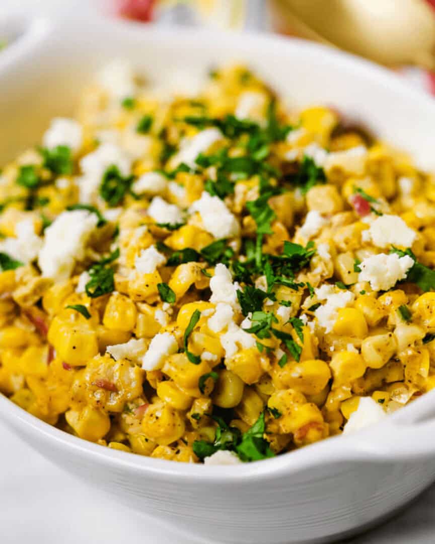 A white serving bowl with the elote salad inside.
