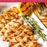 Lemon rosemary chicken on white plate with grilled lemons and rosemary