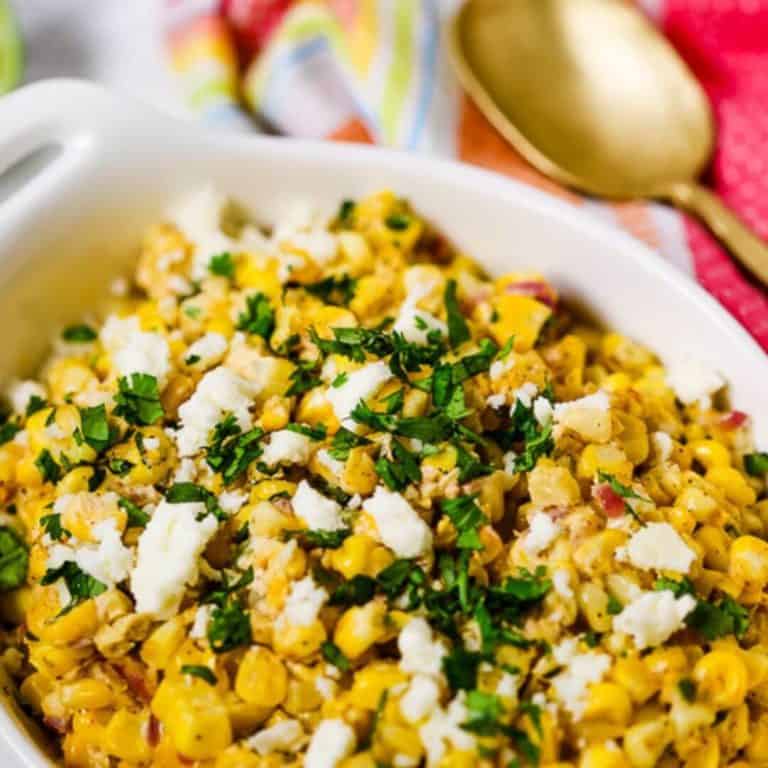 Mexican Corn Salad in a white dish with a gold spoon