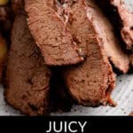 Close-up of sliced smoked brisket on a plate with the text "Juicy Smoked Brisket" below. The tender, well-cooked meat boasts a charred exterior and mouthwatering juiciness.