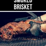 Close-up of a person wearing black gloves lifting a juicy smoked brisket off a grill. The image features the label "Juicy Smoked Brisket" at the top.