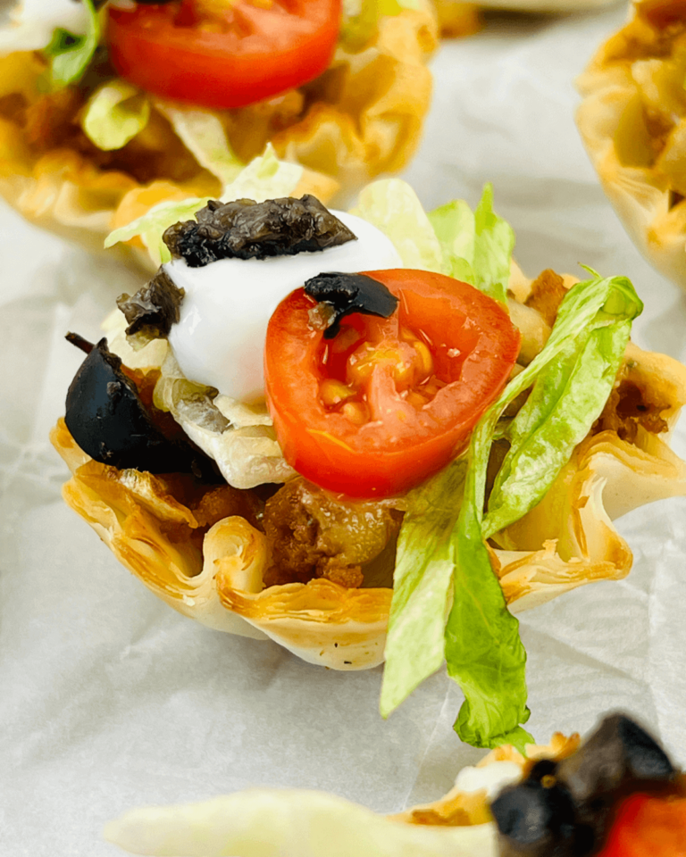 Loaded taco bites with tomatoes, lettuce, and olives.