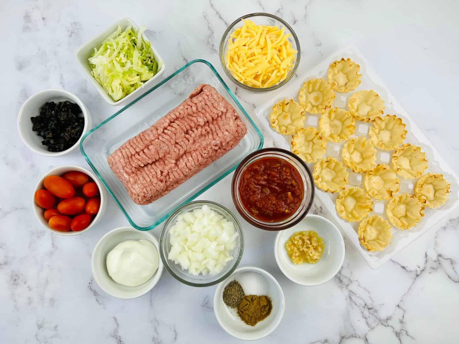 Ground meat, pastry cups and vegetables to make the appetizer.