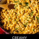 A pot of velvety cheeseburger macaroni, rich with tender veal, awaits its wooden spoon. Herbs are delicately sprinkled on top, adding a burst of freshness.