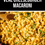 A close-up of a red pan brimming with creamy cheeseburger macaroni and tender veal, garnished with chopped herbs, while a wooden spoon rests invitingly inside.