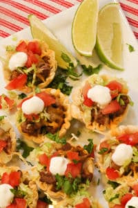 Beef Taco Tarts on a white plate with lime wedges