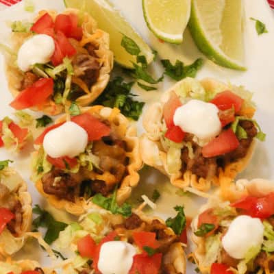Beef Taco Tarts on a white plate with lime wedges