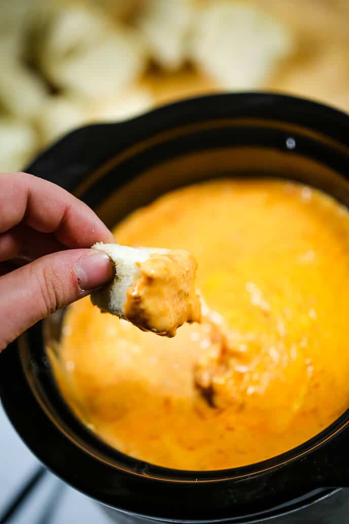 Andy's Pizza Dip recipe in a crockpot with a piece of bread dunked in.