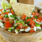 Easy Pico de Gallo salsa in a wooden bowl with tortilla chips.
