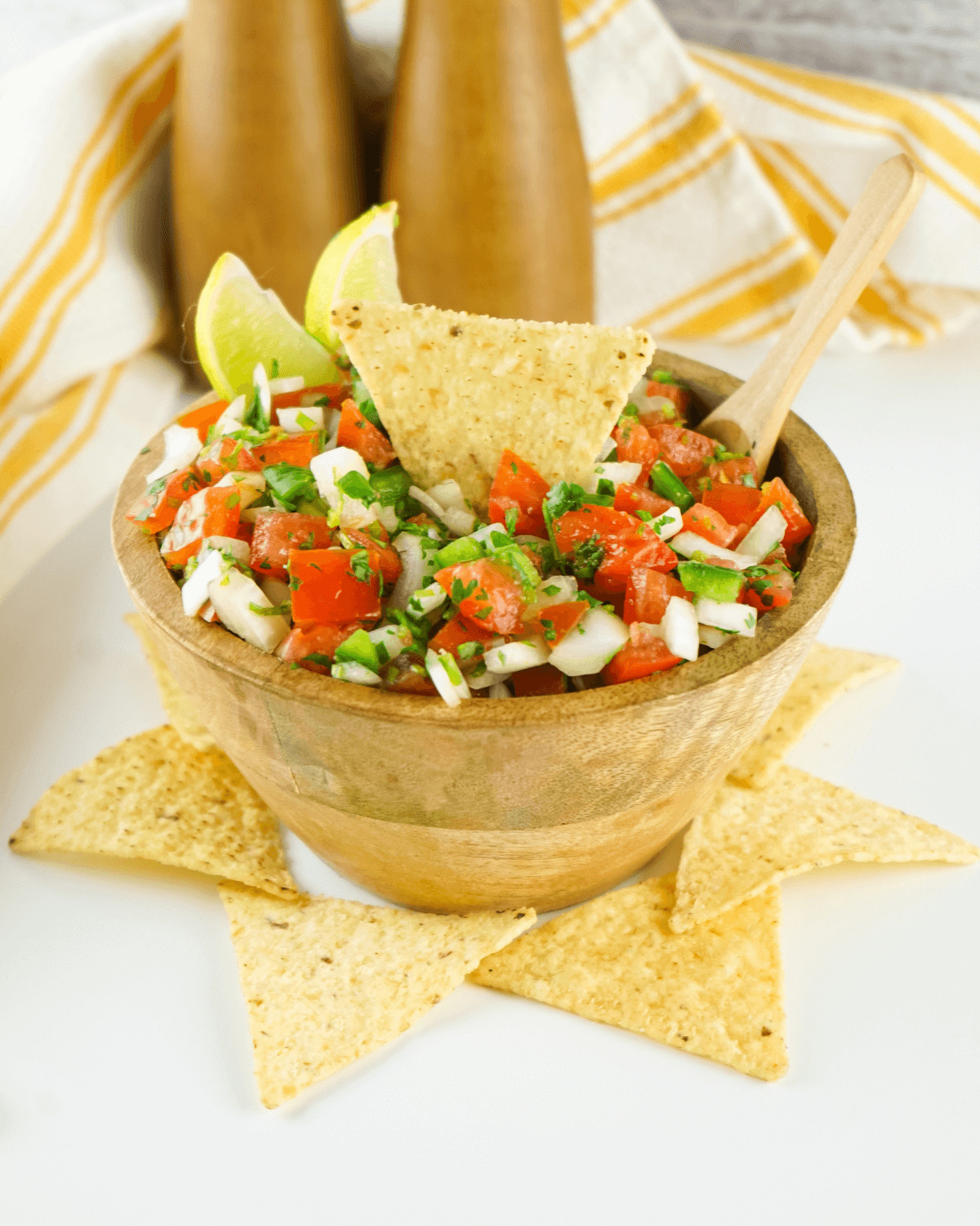 Salsa in a wooden bowl with tortilla chips.