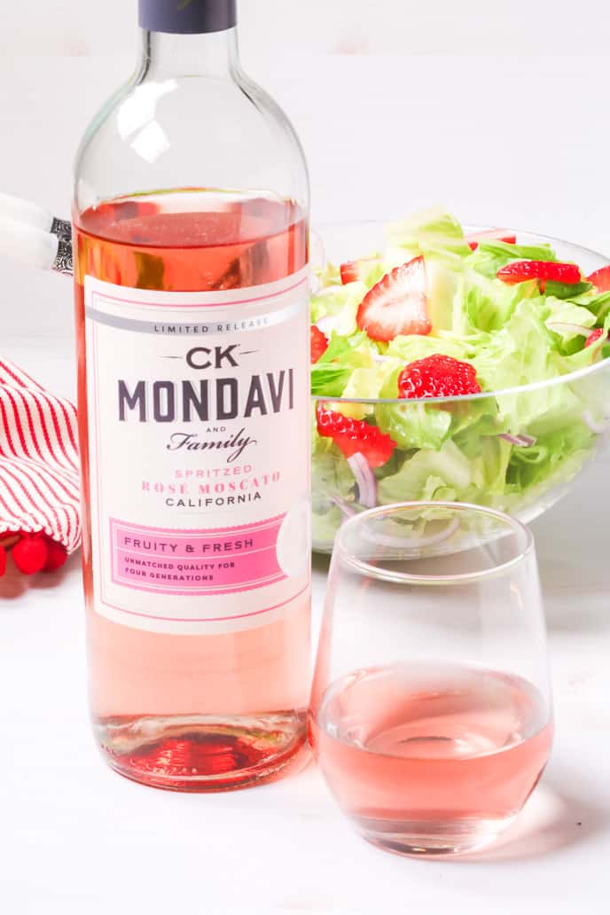 CK Mondavi spritzed Rose moscato wine in a bottle with a glass and salad