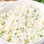 Cilantro lime rice in a white bowl with a gold spoon