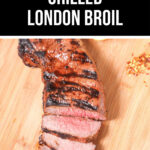 Sliced grilled London broil steak on a wooden cutting board.