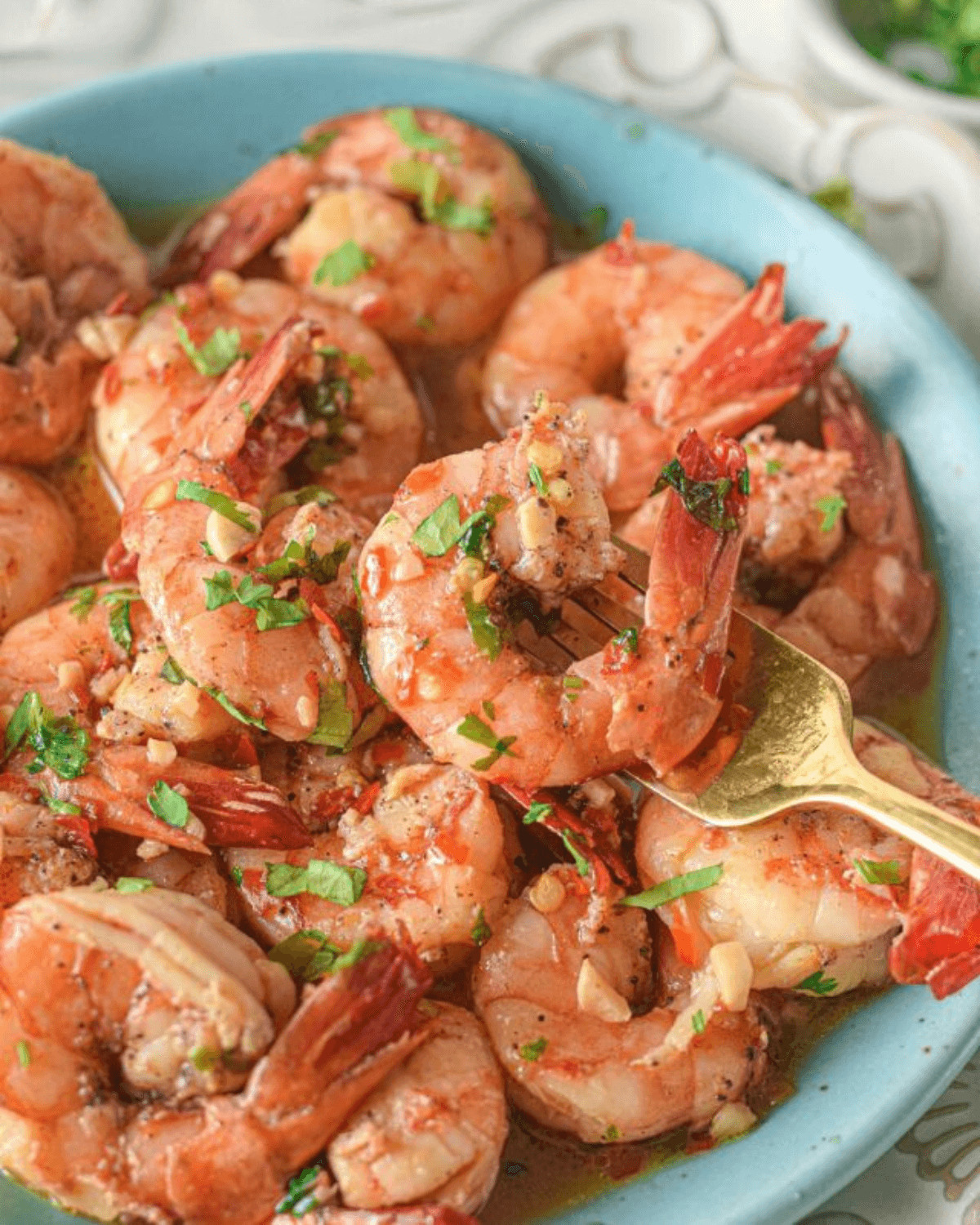 A bowl of Shrimp Scampi without Wine, seasoned and garnished with herbs.