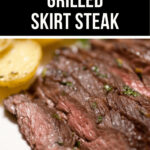 A close-up image of sliced grilled skirt steak garnished with herbs, served with a lemon half, and labeled with the text "balsamic grilled skirt steak" at the top.