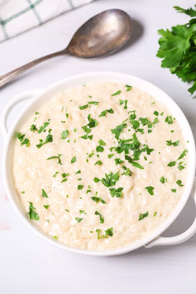 Instant Pot Risotto with chopped parsley in white dish with a spoon