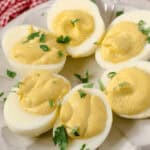 A plate of fancy deviled eggs garnished with fresh parsley.