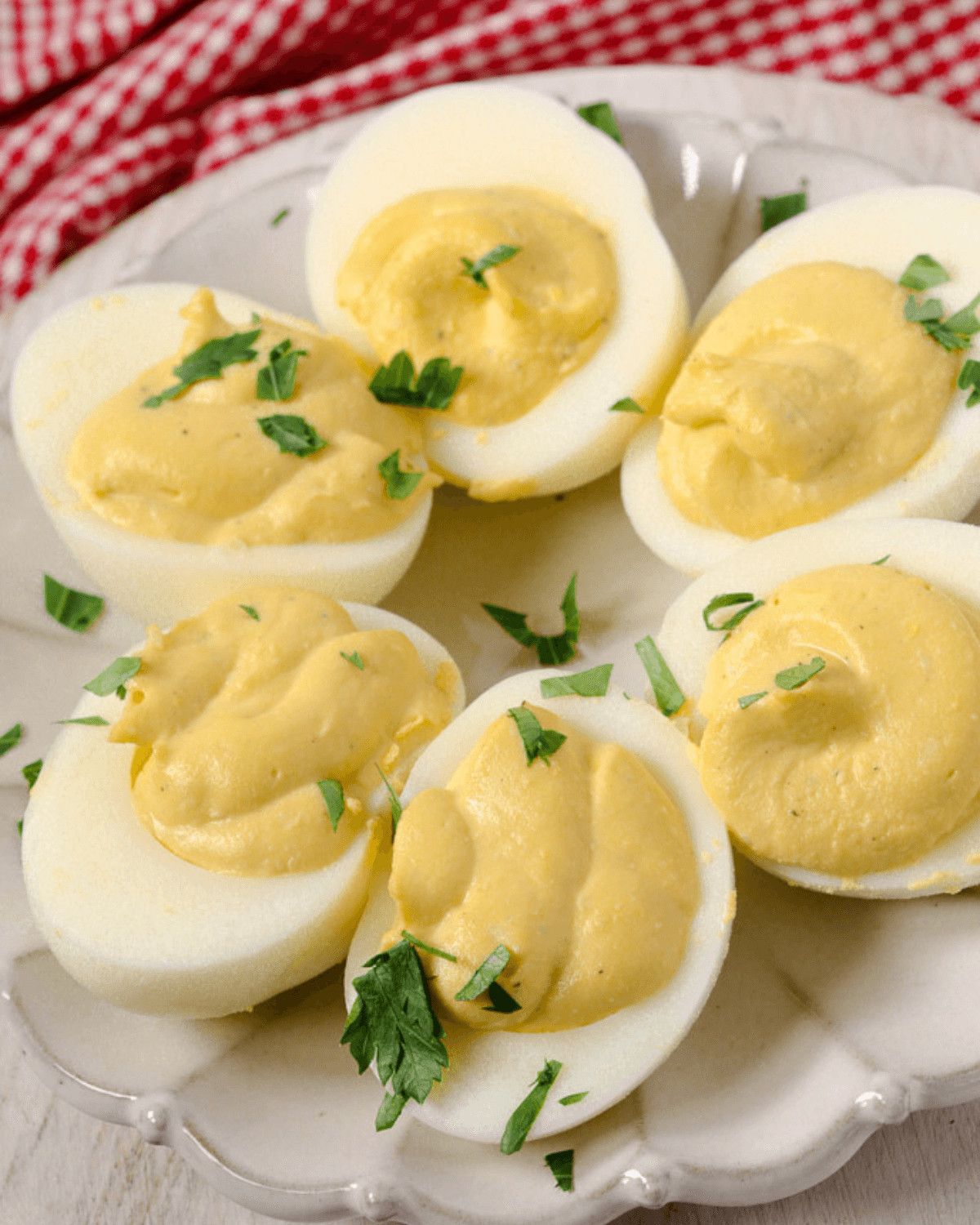 A plate of fancy deviled eggs garnished with fresh parsley.