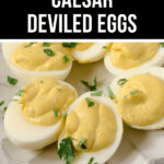 Plate of fancy Caesar deviled eggs garnished with herbs.