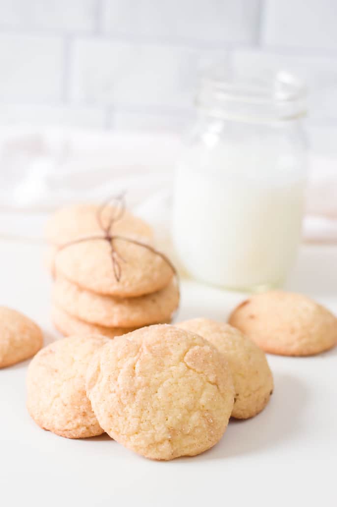 Easy snickerdoodle recipe cookie piled with a glass of milk in the background