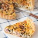 Ham, Cheese and Spinach Quiche on a plaid blue tablecloth