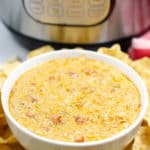 White bowl filled with Instant Pot Queso with Meat and surrounded by chips