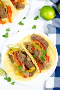 Steak Fajitas in shells on white plate with blue and white check napkin