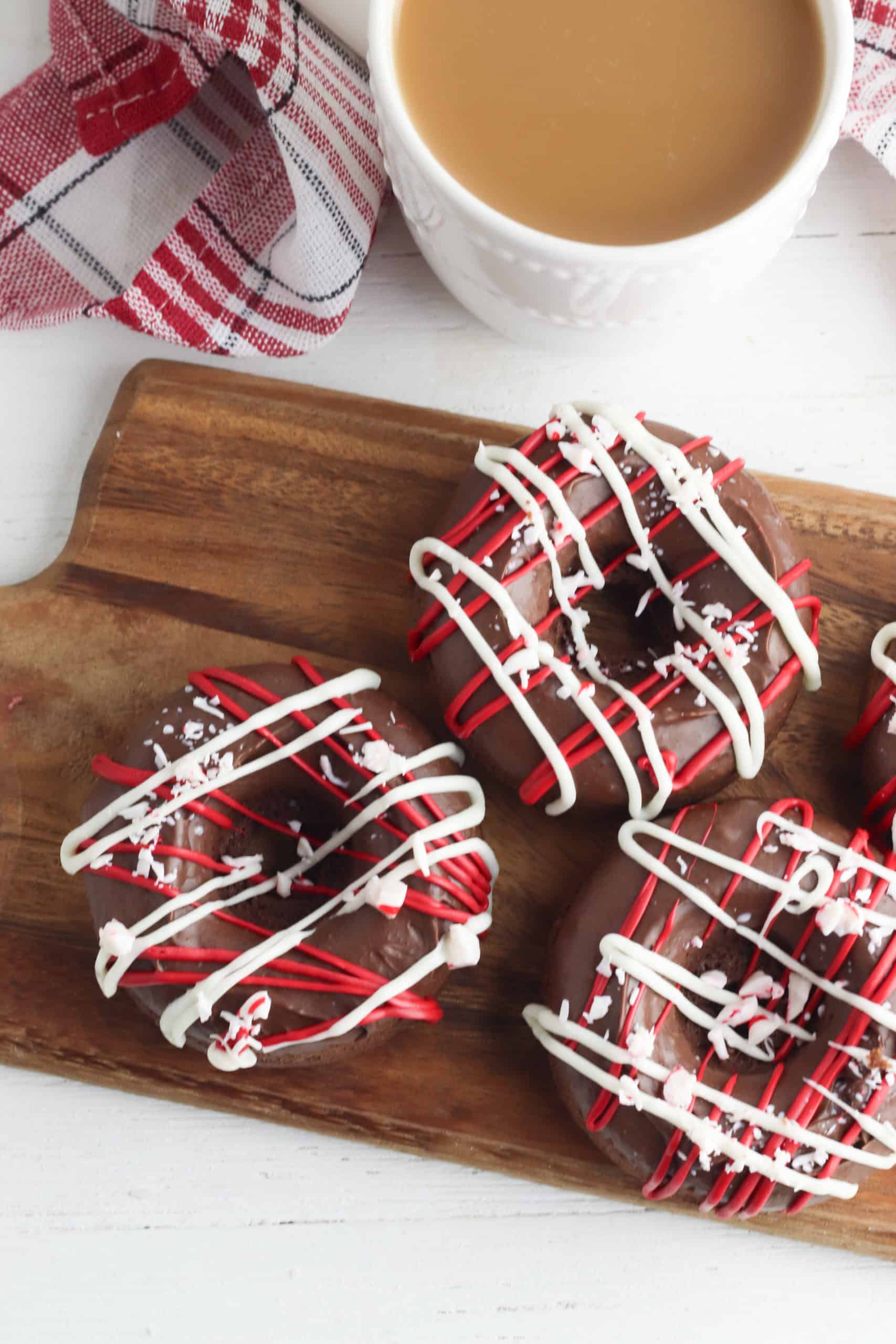 peppermint mocha donuts on a wooden cutting board with plaid napkin