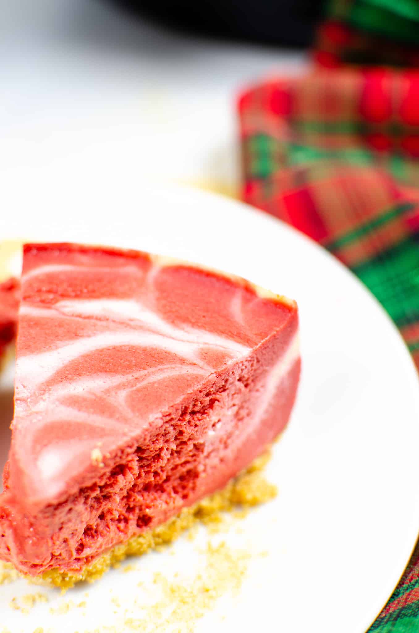 Instant Pot Cheesecake on white plate with red and green plaid napkin