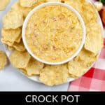 A savory bowl of creamy Crock Pot Queso Dip is surrounded by crunchy tortilla chips, with fresh garlic cloves and spicy jalapeños nearby. The text "Crock Pot Queso Dip" graces the bottom, inviting you to indulge in this irresistible delight.