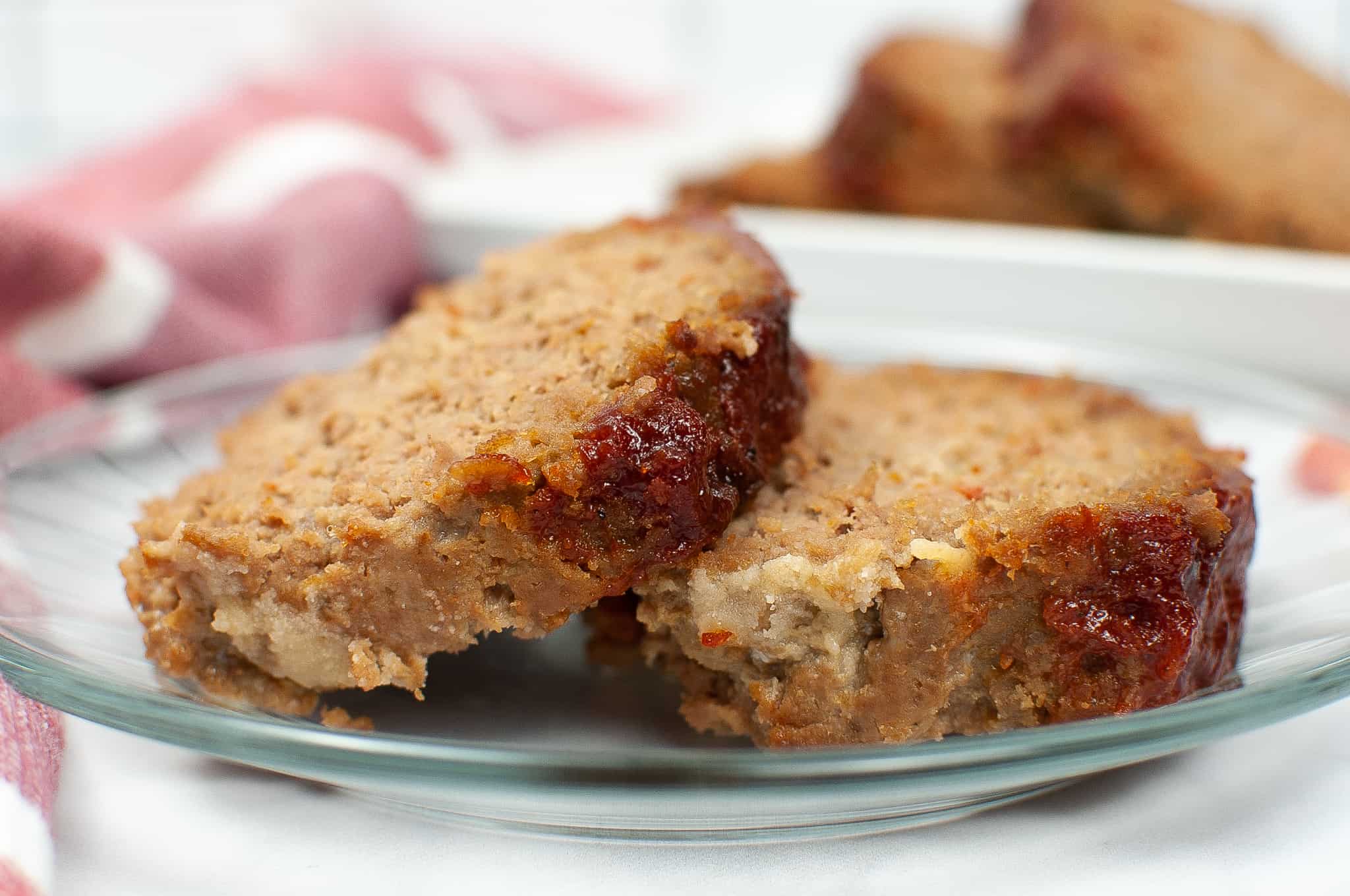 Side view of meatloaf slices on a white dish.