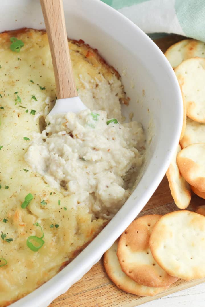 Hot crab dip recipe in a baking dish with a spatula.