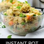 A glass bowl filled with Instant Pot chicken fried rice, featuring tender chicken, peas, and carrots, sits on a counter beside the cooker.